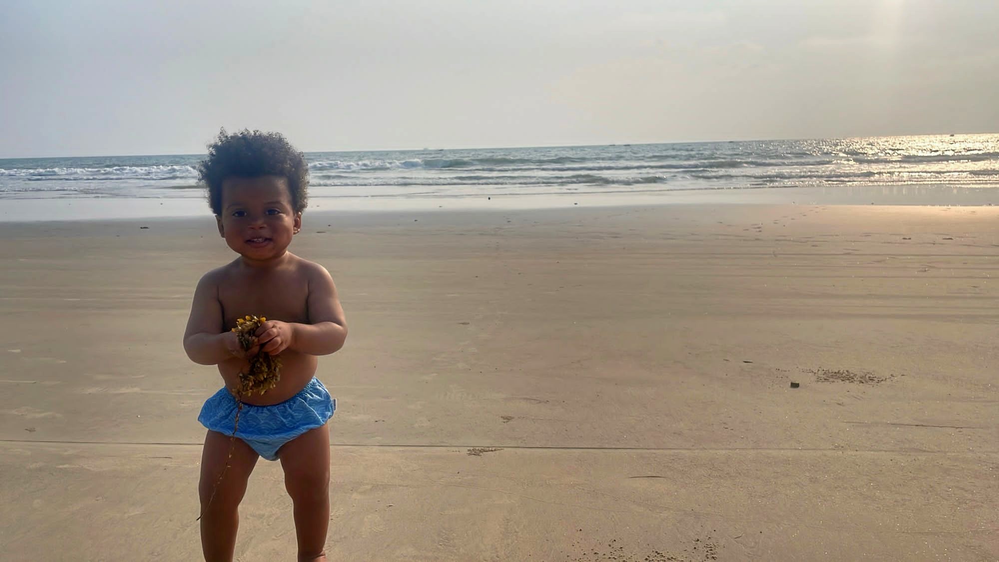 Child standing on a beach.