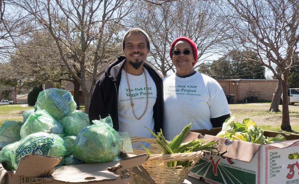 Bettie Montgomery poses with her son Ples, both members of the Oak Cliff Veggie Project. They distribute free produce in front of the Singing Hills Community Garden in Dallas, TX.