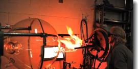Man making a very large glass beaker.