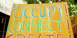 Large Cardboard protes sign reading "OCCUPY! CONNECT! CREATE!"