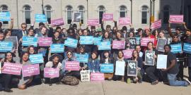 Group of people holding signs that say "Coops build a better Philly"