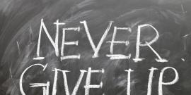 Chalk board reading "never give up"