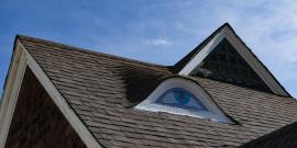 Gable on the roof of a house painted to look like an eye.