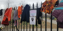 Free store sign on a fence draped with clothes.