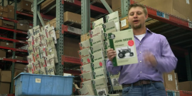 Man holding a John Deere tractor repair manual.