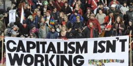 Protesters from Occupy Wall Street holding a banner that reads "capitalism isn't working."