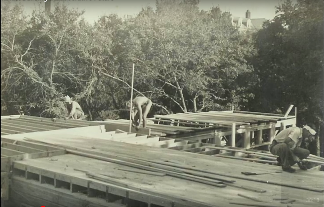 Historical photo of three men constructing a house for a housing cooperative.