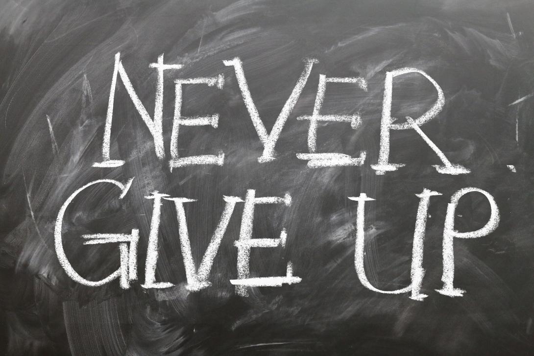 Chalk board reading "never give up"