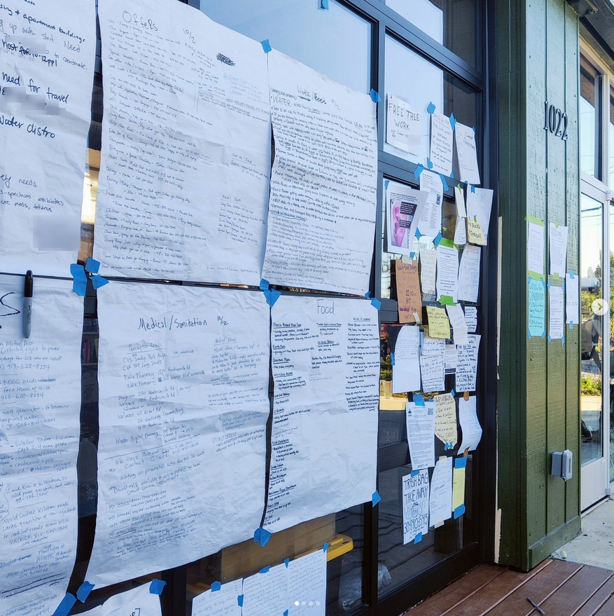 Lists of resources and contacts taped to the front of Firestorm Books.