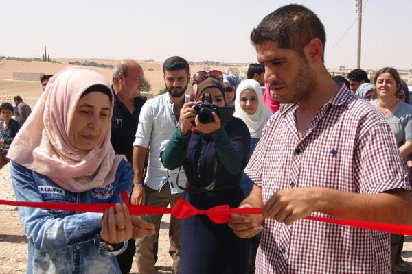Inaugaral celebration of cooperative generator project in Manbij. Image via <a href="https://cooperativeeconomy.info/mualda-cooperative-to-provide-electricity-to-200-houses-in-village-of-manbij/" target="_blank">Co-operative Economy in Rojava & Bajkur</a>.