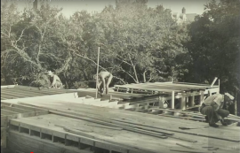 Historical photo of three men constructing a house for a housing cooperative.