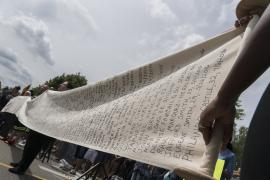 Protesters hold a scroll listing names of people killed by police in Minnesota.