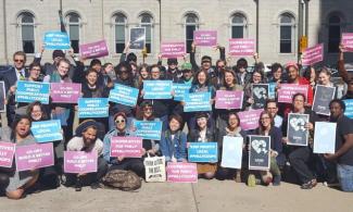 Group of people holding signs that say "Coops build a better Philly"