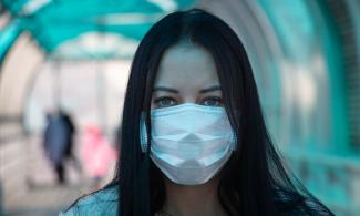 Woman wearing a surgical mask.