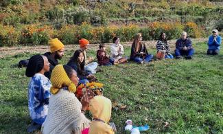 Mumbet's Freedom Farm group sitting in a circle on the grass.