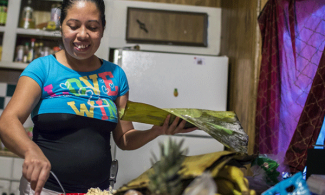 At home in her kitchen, Elideth prepares tamales. She wraps both the masa paste and the chicken and mole sauce in a corn husk and then steams it. Photo by Martin Do Nascimento